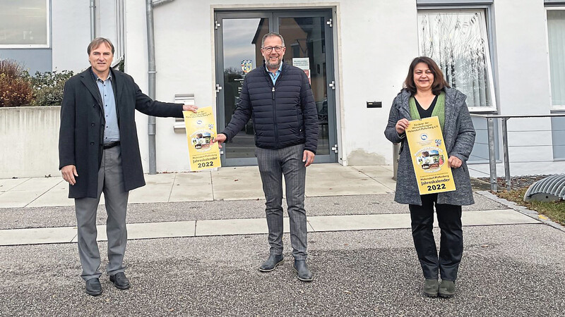 Bürgermeister Christian Dobmeier (Mitte) erhält von Alfred Rottmeier und F. Gerl das erste Exemplar des neuen Kalenders.