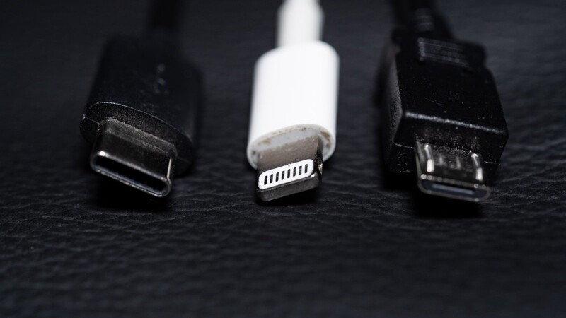 Ein USB-C-Kabel (l.), ein Apple-Lightning-Kabel (M.) und ein Micro-USB-Kabel (r.): Mit dem Kabelsalat soll in der EU Schluss sein, aber erst 2024. Dann soll es bei neuen geräten nur noch USB-C-Kabel geben.