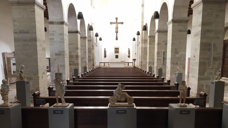 Aus insgesamt 15 gebrannten Tonfiguren besteht der Totentanz von Dr. Angela Eberhard, der noch bis 7. April in der Basilika St. Peter zu sehen ist. Auch vom großen Gitter in der Basilika St. Peter aus kann man alle 15 Figuren des Totentanzes sehen.