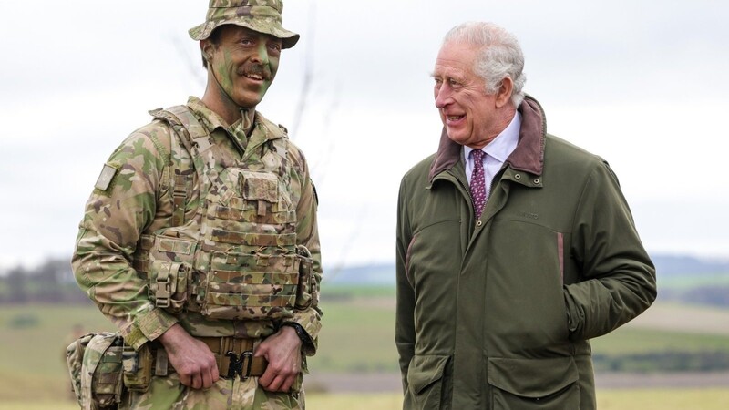 Der britische König Charles III. (r.) trifft Major Tony Harris vor einer Grabenangriffs- und Verteidigungssimulation während eines Besuchs einer Ausbildungsstätte für ukrainische Militärrekruten.