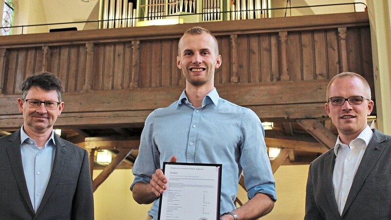 Pfarrer Klaus-Ulrich Bomhard (l.) und Dekanatskantor Carsten Wiedemann-Hohl (r.) gratulierten Falk Caesar Gilch zur erfolgreich absolvierten Orgelprüfung und übergaben das verdiente Zeugnis.