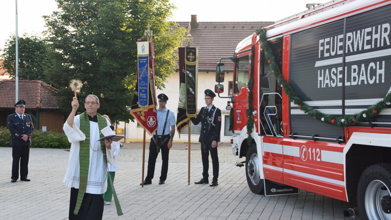 Das Feuerwehrfahrzeug wird am Rathausplatz von Pfarrer Pater Dominik Daschner feierlich gesegnet. Der Kommandant Andreas Fischer (links) sprach anschließend ein paar Worte.
