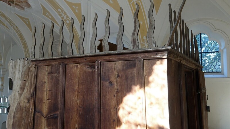 Orgelumbau auf der Empore mit pfingstlichen Feuerzungen aus Holz.