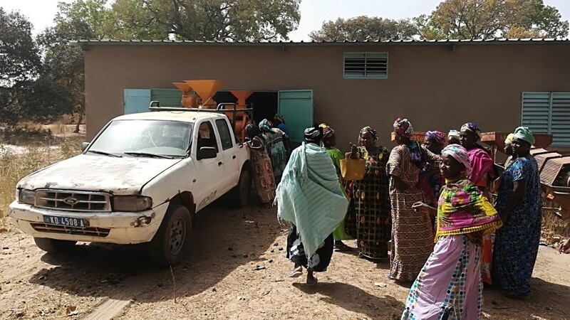 Die Einwohner des Ortes Tankanton Escale bei der Auslieferung einer Verarbeitungsmaschine für Hülsenfrüchte