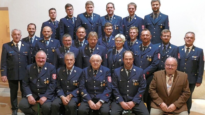 Kreisbrandinspektor Johann Haller (l.), Kreisbrandmeister Florian Reisinger (mittlere Reihe, 2.v.r) und Bürgermeister Ludwig Robold (1. Reihe,r.) gratulierten den beförderten und geehrten Feuerwehrkameraden.
