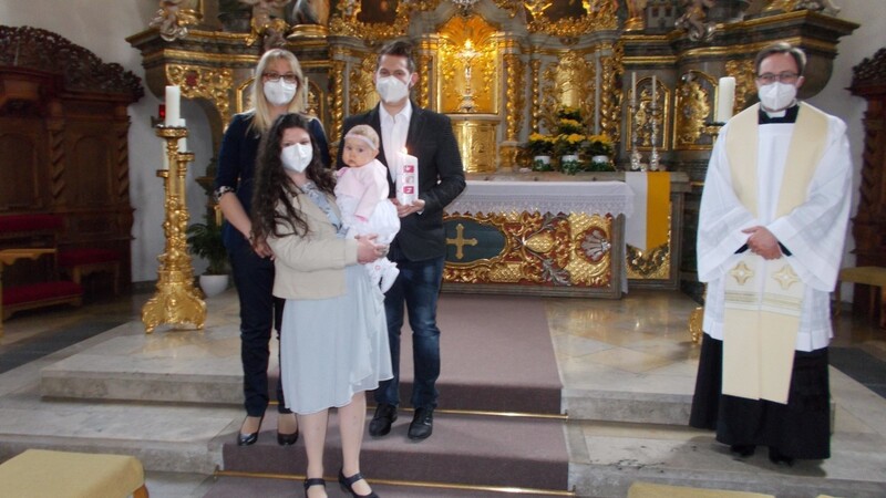 Die kleine Saskia zusammen mit ihren Eltern und ihrer Patin nach der Taufe am Altar der Stadtpfarrkirche.