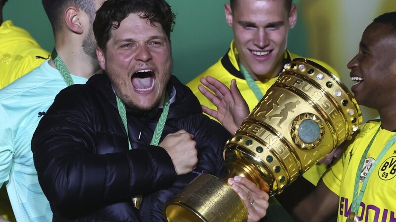 Edin Terzic (M.), Dortmunds Cheftrainer, hält den Pokal im Arm und feiert mit der Mannschaft. Ob er im kommenden Jahr noch beim BVB ist, steht in den Sternen.