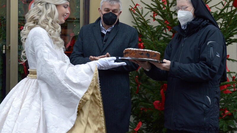 Einen Kuchen für das Engagement der Armen Schulschwestern Moosburg überreicht das Moosburger Christkind.