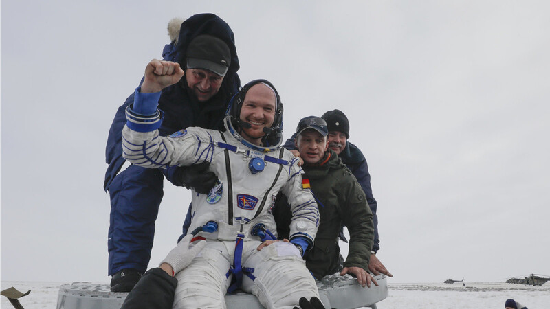 Personal hilft Alexander Gerst nach der Landung aus der Sojus-Raumkapsel.