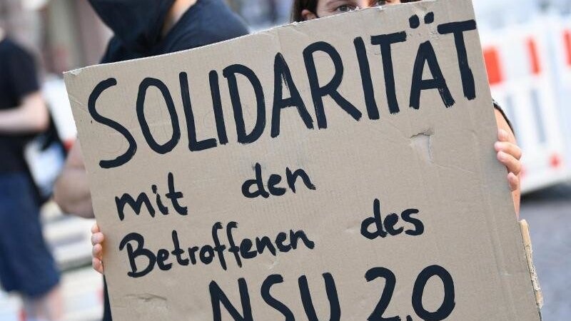 Eine Frau hält bei einer Kundgebung ein Schild mit der Aufschrift "Solidarität mit den Betroffenen des NSU 2.0".