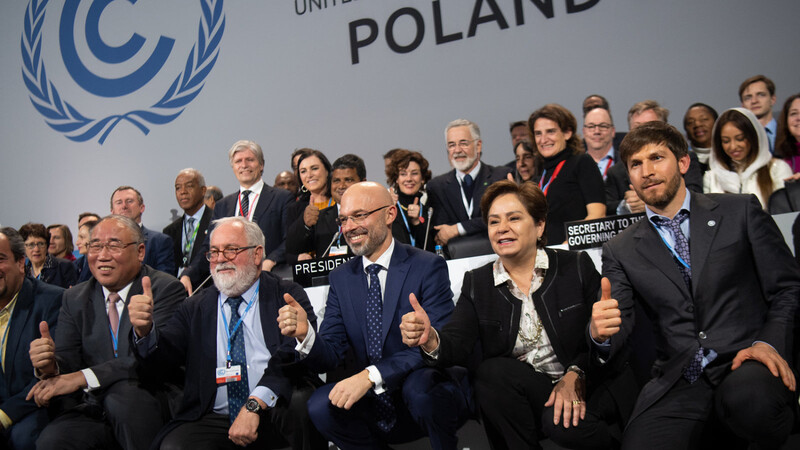 Der Präsident der UN-Klimakonferenz, Michal Kurtyka (vorne, Mitte), freut sich mit zahlreichen Teilnehmern über den Beschluss des Kompromisses.