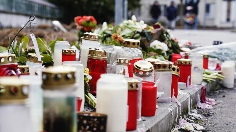 Blumen und Kerzen liegen vor dem Universitätsgebäude in Heidelberg, nachdem am Montag bei einem Amoklauf eine 23-jährige Studentin getötet und drei weitere Menschen verletzt wurden.