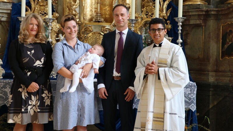 Die Taufe erhielt am Sonntag die fünf Monate alte Marlene Anna Schötz, die die Taufpatin Marion Schötz auf dem Arm hält. Mit im Bild die Eltern und rechts Pfarrvikar Eldivar Pereira Coelho als Taufspender.