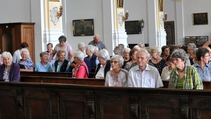 Die Besucher nehmen Platz zur Kirchenführung.