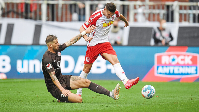 Guido Burgstaller (l.) von St. Pauli, der Jahn-Spieler Erik Wekesser in dieser Szene den Ball weggrätscht, ist mit seinen beiden Treffern der Matchwinner der Kiezkicker.