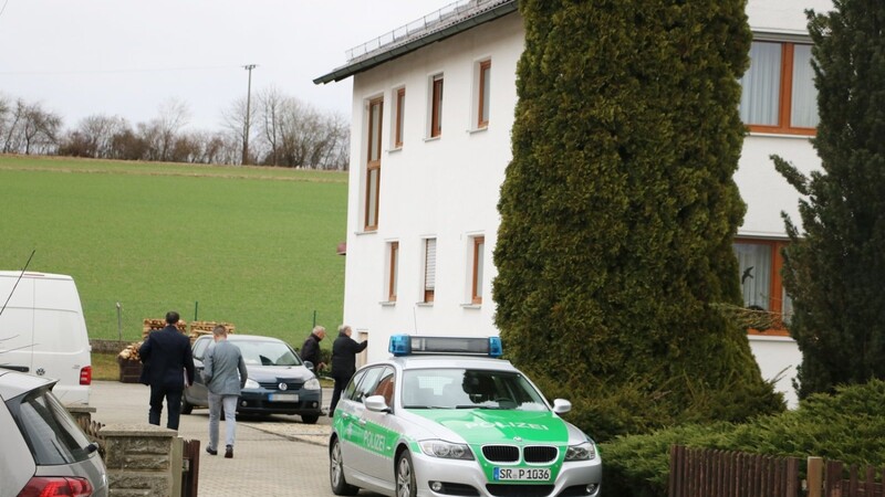 In dem Familienhaus in Ascholtshausen wurden die drei Leichen gefunden. Kriminalbeamte, Polizei und Spurensicherung gingen dort am Montag ein und aus. Im Hintergrund wird ein Fenster im Erdgeschoss mit Brettern verschlossen.