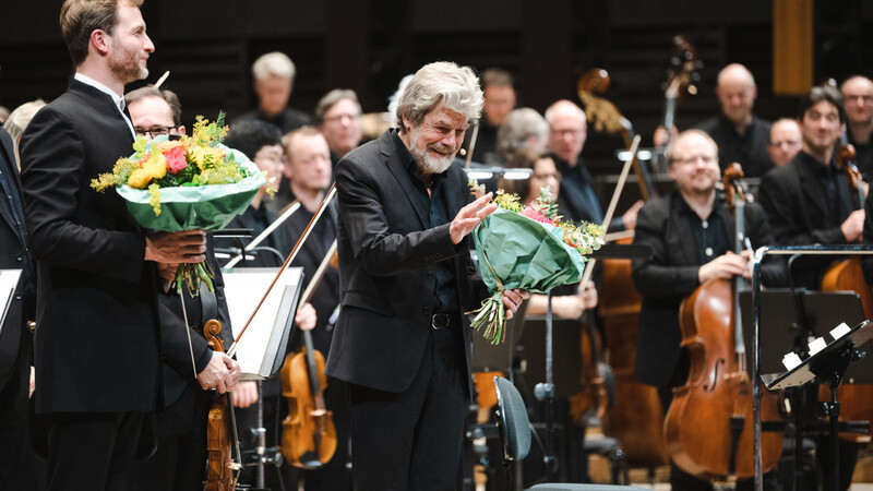 Der Dirigent Christian Schumann mit Reinhold Messner und den Stuttgarter Philharmonikern in der Isarphilharmonie.