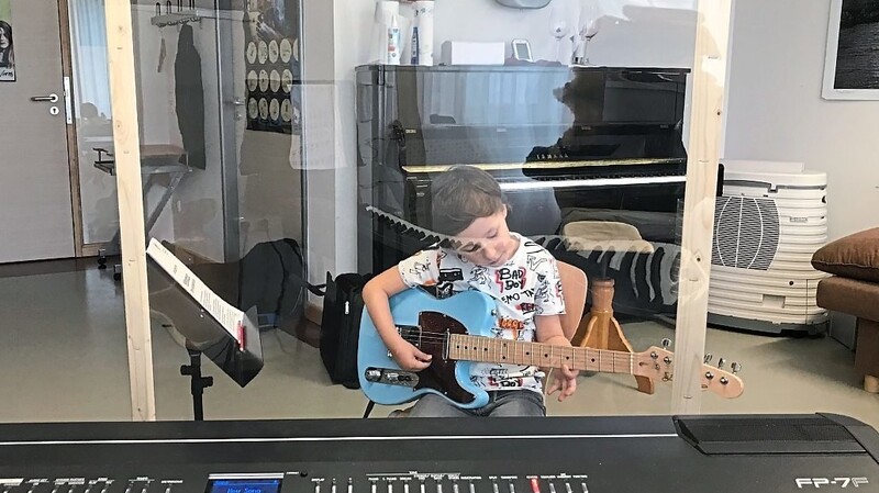 In allen Unterrichtsräumen der städtischen Musikschule trennt Schüler und Lehrer eine Plexiglasscheibe, wie hier den sechsjährigen Leonardo Weiß.