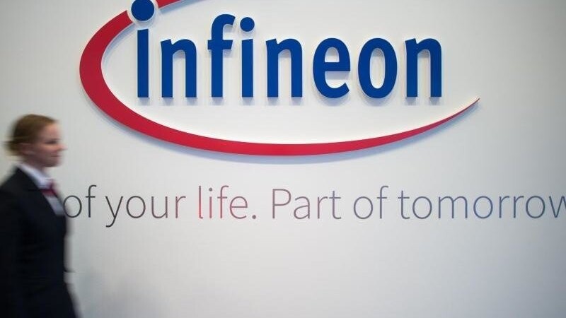 Frau geht an Infineon-Logo vorbei. Foto: Matthias Balk/Archivbild