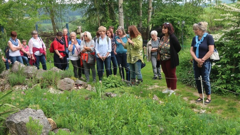 Mitglieder des Gartenbauvereins Kollnburg vor dem "Alpinum" in Bärbels Garten, in der Mitte Barbara Krasemann bei ihren Erklärungen.