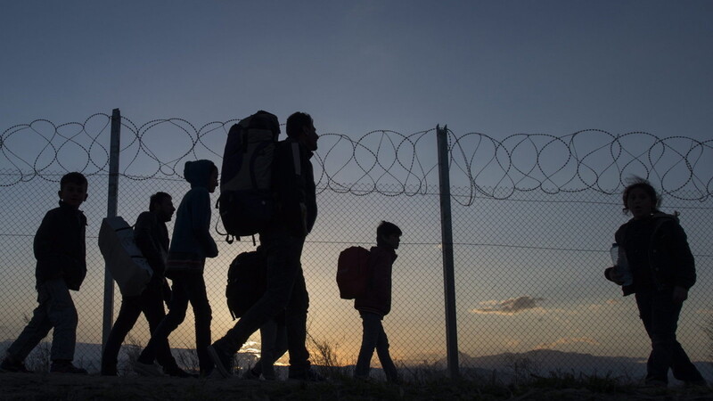 Flüchtlinge sind im Jahr 2016 auf dem Weg zu einem Transit-Camp, nachdem sie die Grenze zwischen Griechenland und Mazedonien überschritten haben.