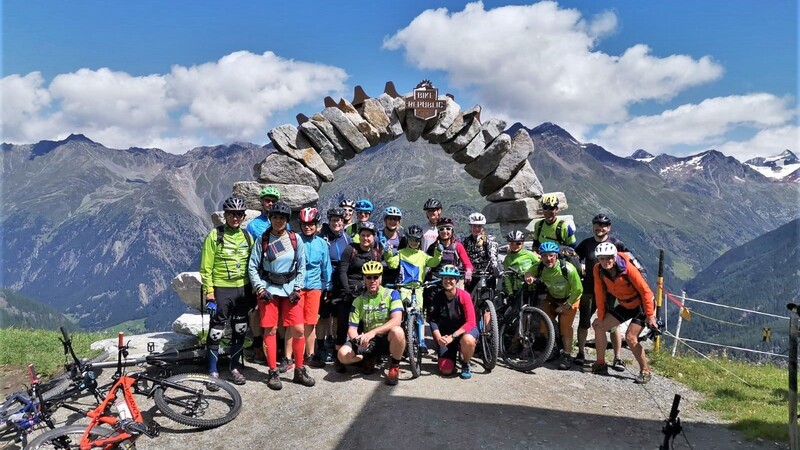 Gruppenfoto vor Bergpanorama: die Ski&Bike-Radler an einem Einstiegsportal in die Bikeparkstrecken um den Gaislachkogel.