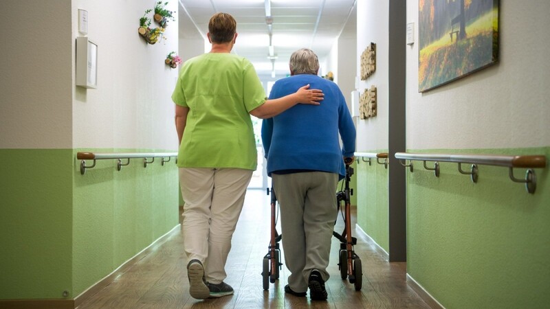 Eine Pflegefachkraft begleitet eine Seniorin auf dem Gang. Schon heute sind 30 Prozent der Heimbewohner auf Sozialhilfe angewiesen - Tendenz steigend.