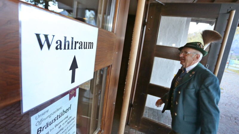 Ein Mann in bayerischer Tracht betritt ein Wahllokal für die Landtagswahl in Bayern.