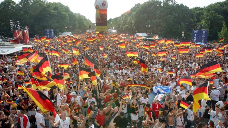 ARCHIV - Fans der deutschen Fußball-Nationalmannschaft schwenken Fahnen während der Fußball-WM 2006 beim Fan-Fest in Berlin (Archivfoto vom 24.06.2006).