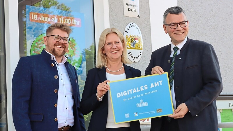 Digitalminister Florian Herrmann (rechts) überreichte das offizielle Schild an Susanne Hoyer und Bernhard Götz.