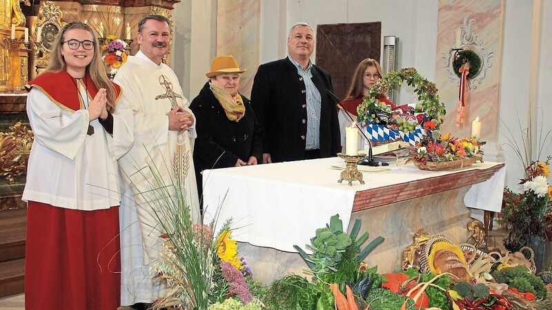 Pfarrer Albert Vogl und seine Haushälterin Maria Werner zusammen mit Pfarrgemeinderatsvorsitzendem Lothar Fischer sowie den Ministranten am Erntedankaltar.