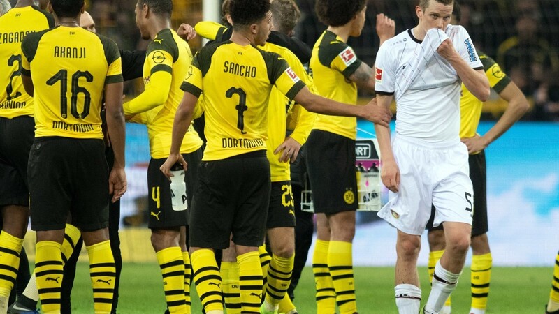 Die Dortmunder Spieler feiern ihren Sieg, Leverkusens Sven Bender (rechts) ist deprimiert.