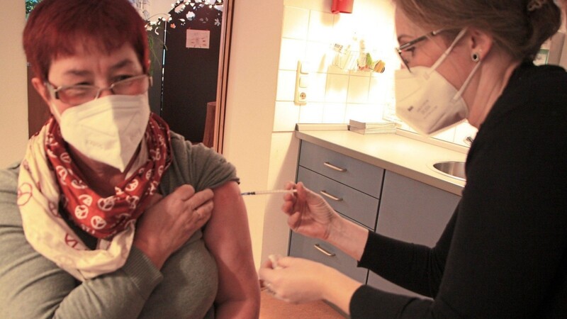 Patientin Elke Bösl (links) krempelt den Ärmel für die Corona-Boosterimpfung hoch.
