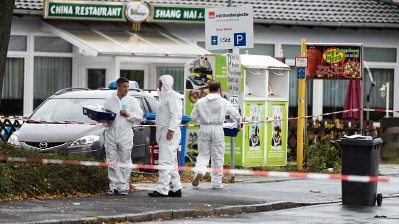 Ermittler der Polizei stehen am abgesperrten Tatort. Eine etwa 45 Jahre alte Frau ist am Donnerstag in Göttingen auf einer Straße von einem Mann getötet worden.