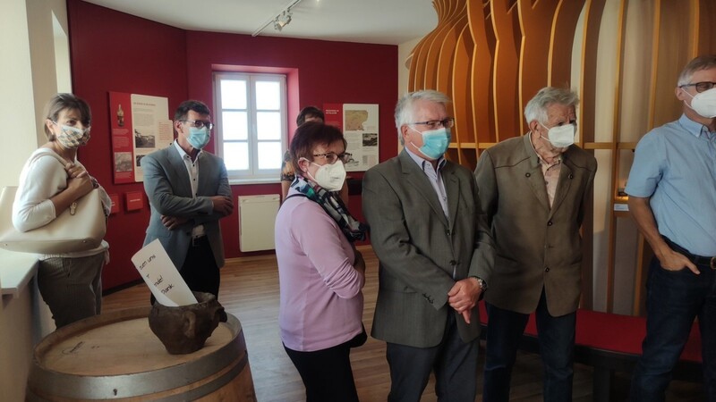 Die Besucher des Museums verfolgen interessiert die Filme in der Heimatecke, unter ihnen auch Bürgermeister Rudi Radlmeier mit Ehefrau - von der Glockenweihe 1950, über den Weinanbau bis hin zum Bau des Keltenhauses 2018/19.