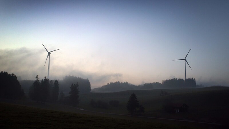 Windräder ragen bei Kraftisried in Bayern aus dem Nebel. Grüne und SPD wollen mehr Windkraft in Bayern, die CSU hält bislang an der "10H"-Regel fest, die den Abstand von Windrädern zum nächsten Wohngebiet regelt (Archivbild).