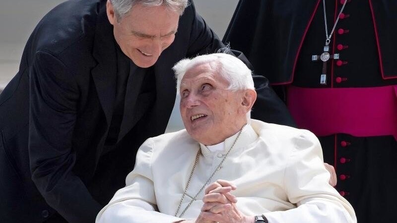 Georg Gänswein (l) und der emeritierte Papst Benedikt XVI. stehen am Flughafen für ein Foto zusammen.