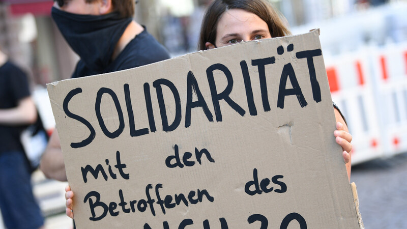 Eine Demonstrantin hält während einer Kundgebung in der Wiesbadener Innenstadt ein Plakat mit der Aufschrift "Solidarität mit den Betroffenen des NSU 2.0" (Archivfoto). Ein mutmaßlicher Verfasser von rechtsextremen Drohschreiben mit dem Absender "NSU 2.0" ist in Berlin bei einer Wohnungsdurchsuchung festgenommen worden.
