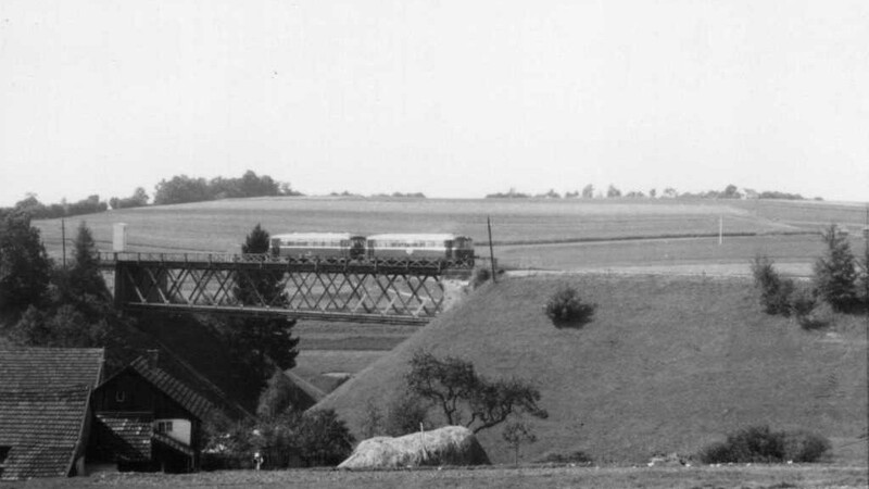 Ein Schienenbus fährt um 1960 über die Klinggrabenbrücke von Steinberg nach Griesbach, im Hintergrund wäre heute der "Keltenring".