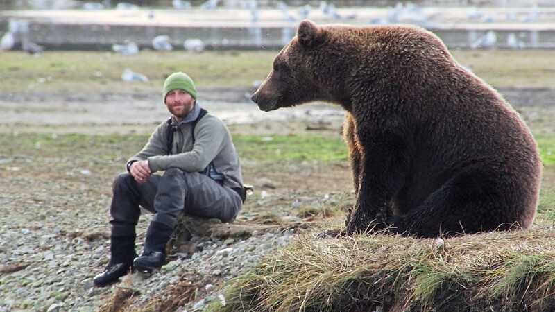 Der Biologe David Bittner neben einem Grizzlybär