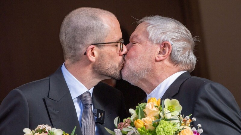 Der ehemalige Benediktiner-Mönch Anselm Bilgri (r) und sein Mann Markus küssen sich 2021 nach ihrer standesamtlichen Trauung.