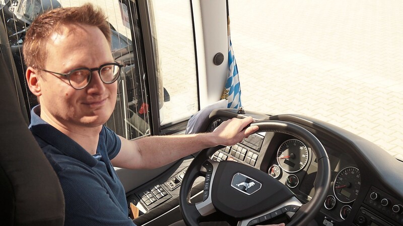 Tobias Frey, einer der beiden Geschäftsführer des Busunternehmens "Frey Reisen" in Großköllnbach, sitzt am Steuer eines der hauseigenen Fahrzeuge.