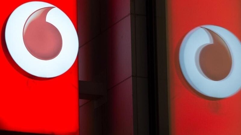 Das Logo von Vodafone spiegelt sich in der Fensterscheibe einer Verkaufsfiliale des Unternehmens.
