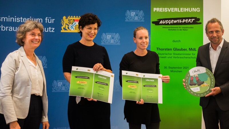Strahlende Preisträgerinnen: Katrin Roiger (2.v.l.) und Theresa Hinkofer (2.v.r.) erhalten aus den Händen von Umweltminister Thorsten Glauber (r.) den ersten Preis für ihre Kampagne.