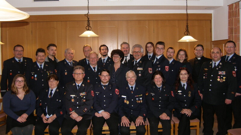 Die Feuerwehrfamilie mit Ehrengästen um den 1. Kommandanten Helmut Leberfinger und Vorsitzenden Hans Beham (sitzend, 3. und 5. v.l.).