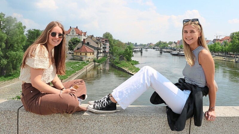 Diese beiden Studentinnen leben gefährlich: Sie genießen die Frühlingssonne auf der Mauer der Steinernen Brücke.