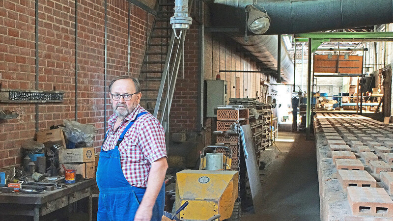 Firmenchef Franz Senft in einer der Produktionshallen. Links ist der 60 Meter lange Ofen zu erkennen, rechts sieht man die Ofenwagerl.