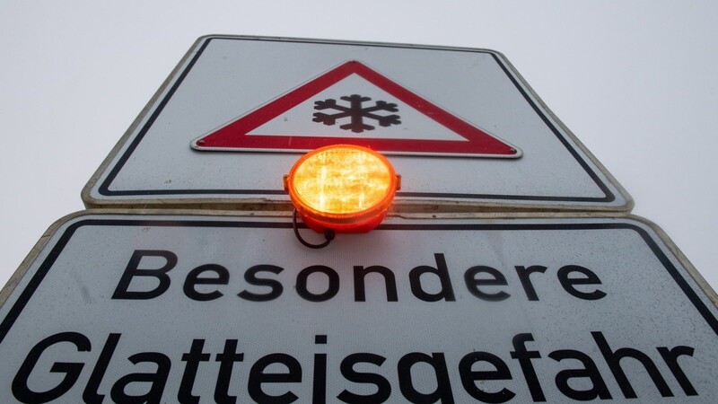 Ein Straßenschild warnt mit einer Blinkleuchte vor Glatteis. Für den Vormittag wurde im Süden vor Eisregen gewarnt. +++ dpa-Bildfunk +++