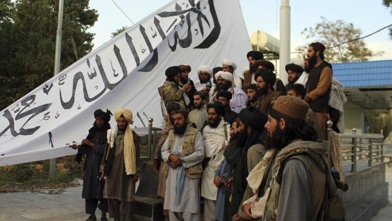 Taliban-Kämpfer posieren in der Provinz Gasni mit ihrer Fahne vor dem Haus des Gouverneurs.