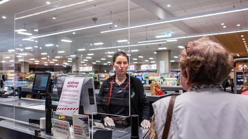 In einem Supermarkt in Rheinfelden in Baden-Württemberg wird die Kassiererin von einer Plexiglasscheibe geschützt.